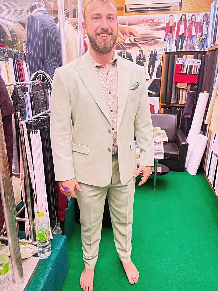 Client in a sage-green linen suit made by Unique Custom Tailor
